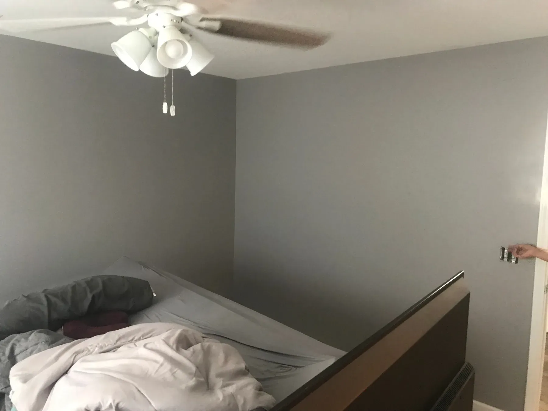 A bedroom repainted in a soft gray with crisp white trim