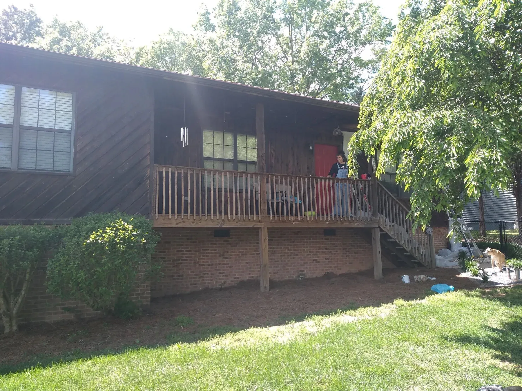A two-story home with dark brown siding before painting