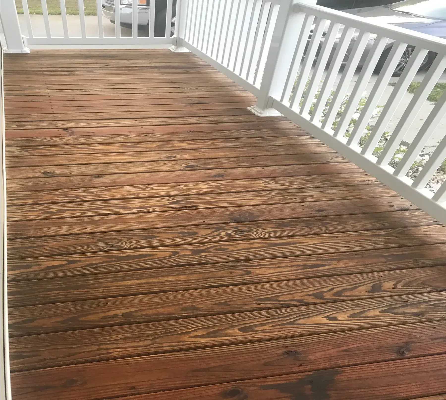 A freshly stained porch floor with white rails